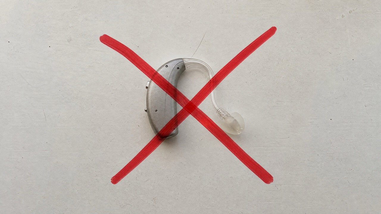 A conventional hearing aid crossed out with a red X